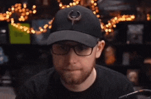 a man wearing glasses and a hat with a quake logo