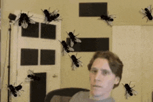 a man is sitting in a chair surrounded by flies .