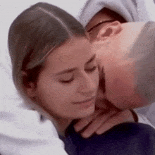 a man is kissing a woman on the forehead