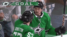 a hockey player in a green jersey has the number 53 on his back