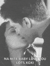 a man and a woman kissing in a black and white photo .