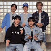 a group of young men are posing for a picture with one wearing a black hoodie that says men
