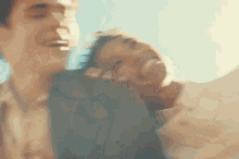 a man and a woman are laughing and hugging each other .
