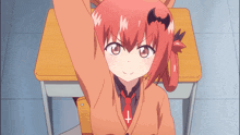 a girl with red hair is sitting at a desk with her arms up