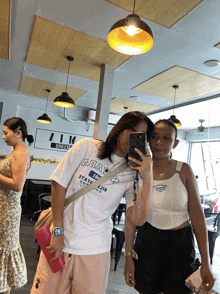 a woman wearing a shirt that says ' aoa ' on it takes a selfie