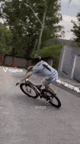 a man is riding a bike down a street with a viggle.ai watermark