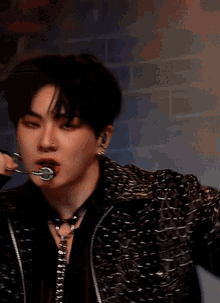 a blurry picture of a man wearing a black jacket and a necklace