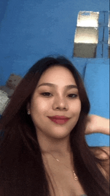 a woman with long hair and a necklace is smiling