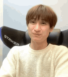 a man sitting in a striker chair making a funny face