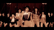 a group of women wearing suits and hats are dancing together