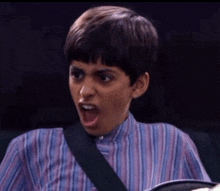 a young boy wearing a striped shirt with his mouth open