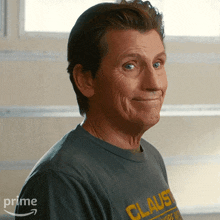a man wearing a grey shirt that says claust on it