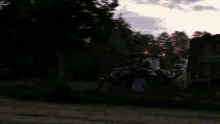 a blue and white tractor is driving through a field at night