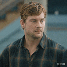 a man in a plaid shirt has a netflix logo on his chest
