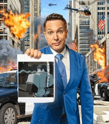 a man in a blue suit and tie is holding a picture of a robot