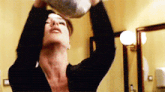 a woman in a black sweater is holding a bag over her head