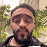 a man with glasses and a beard is making a face