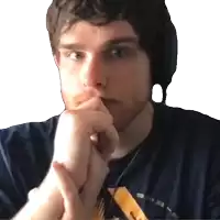 a man wearing headphones and a blue shirt has his hands folded in front of his chin