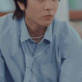 a young man in a blue shirt is eating a french fries