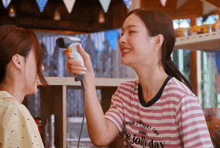 a woman wearing a pink and white striped shirt that says enjoy your happy life on jolly day