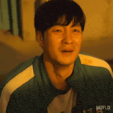 a close up of a man 's face with a tear running down his cheek .