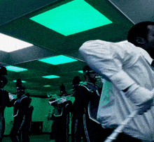 a man in a white shirt is playing a trumpet