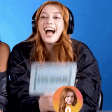 a woman wearing headphones is holding a sign that says u