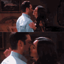 a man and woman are kissing in a room with a painting on the wall