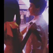 a man and a woman are standing next to each other in a crowded room .