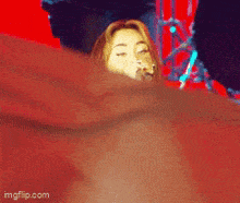 a woman singing into a microphone with a red background