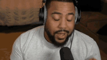 a man with a beard is wearing headphones and talking into a microphone