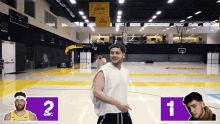 a man in a white tank top stands on a basketball court in front of a lakers banner