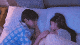 a man and a woman are sleeping next to each other in bed .