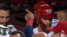 a baseball player wearing a red helmet with the letter w on the front