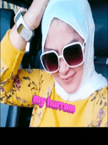 a woman wearing sunglasses and a hijab with the words my hurrem written on her chest