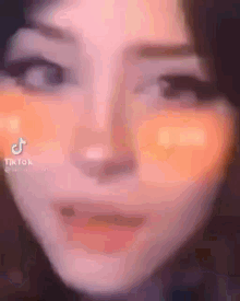 a close up of a woman 's face with a tik tok logo on it