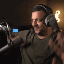 a man wearing headphones and a microphone is smiling