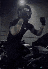 a man wearing a helmet is riding a motorcycle down a street at night