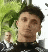 a close up of a man wearing a monster energy shirt and looking at the camera .