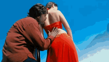a man is touching a woman 's butt in a red dress