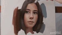 a person is painting a woman 's face on a canvas ..