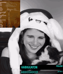 a black and white photo of a woman wearing a bunny hat and holding a cat