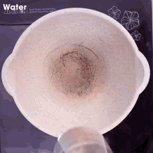 a dirty pot sits on a stove top with a water sign above it