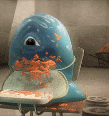 a blue monster is eating a piece of bread on a school desk