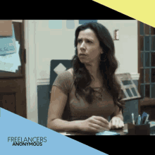 a woman sitting at a desk with the words freelancers anonymous on the bottom right