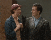 two men are standing next to each other and one of them is wearing a hard hat