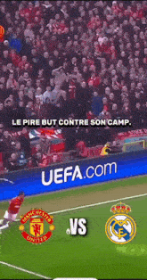 a soccer game between manchester united and real madrid with a uefa.com ad in the background