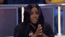 a woman sitting in front of a microphone with bet written on the bottom