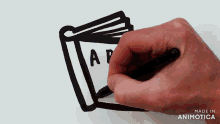 a hand is drawing a book with the letter ap on it