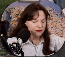 a woman is singing into a microphone in a bedroom